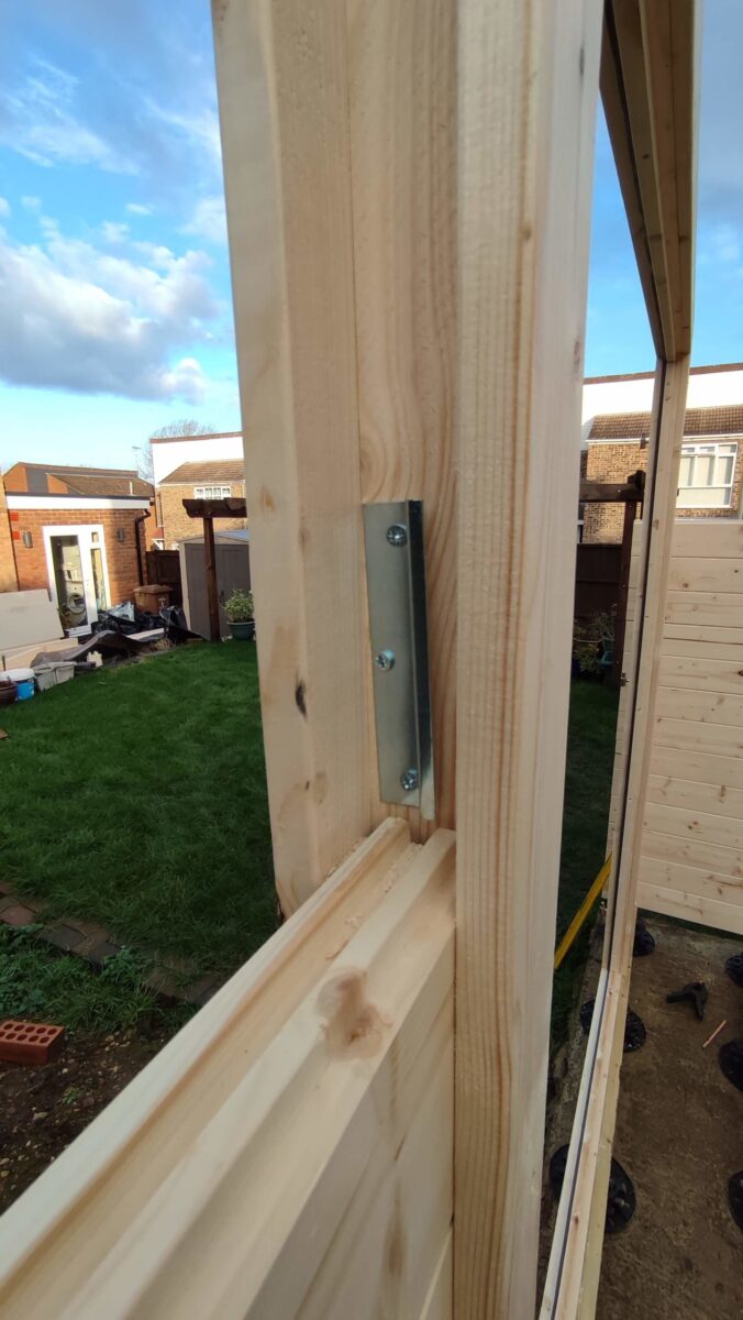 The metal bracket which keeps the door frame and logs in registration