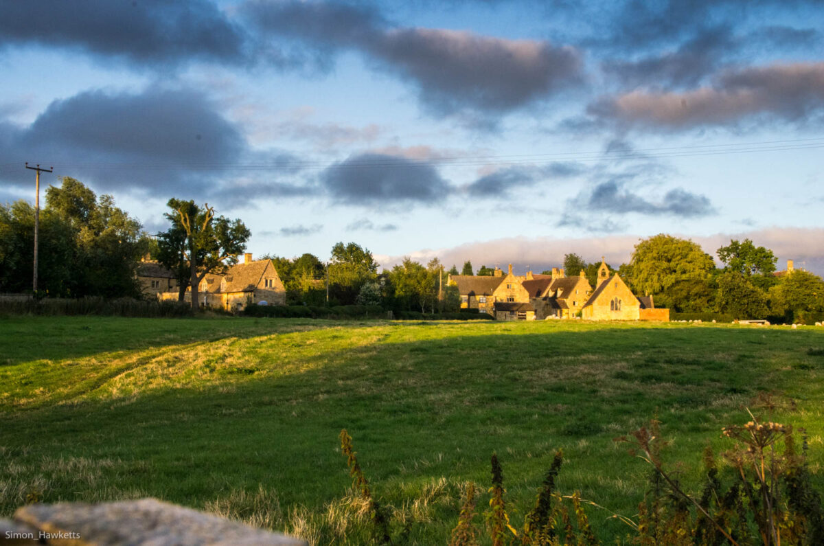 Grass fields and a Church in the distance in Evening Sunshine
